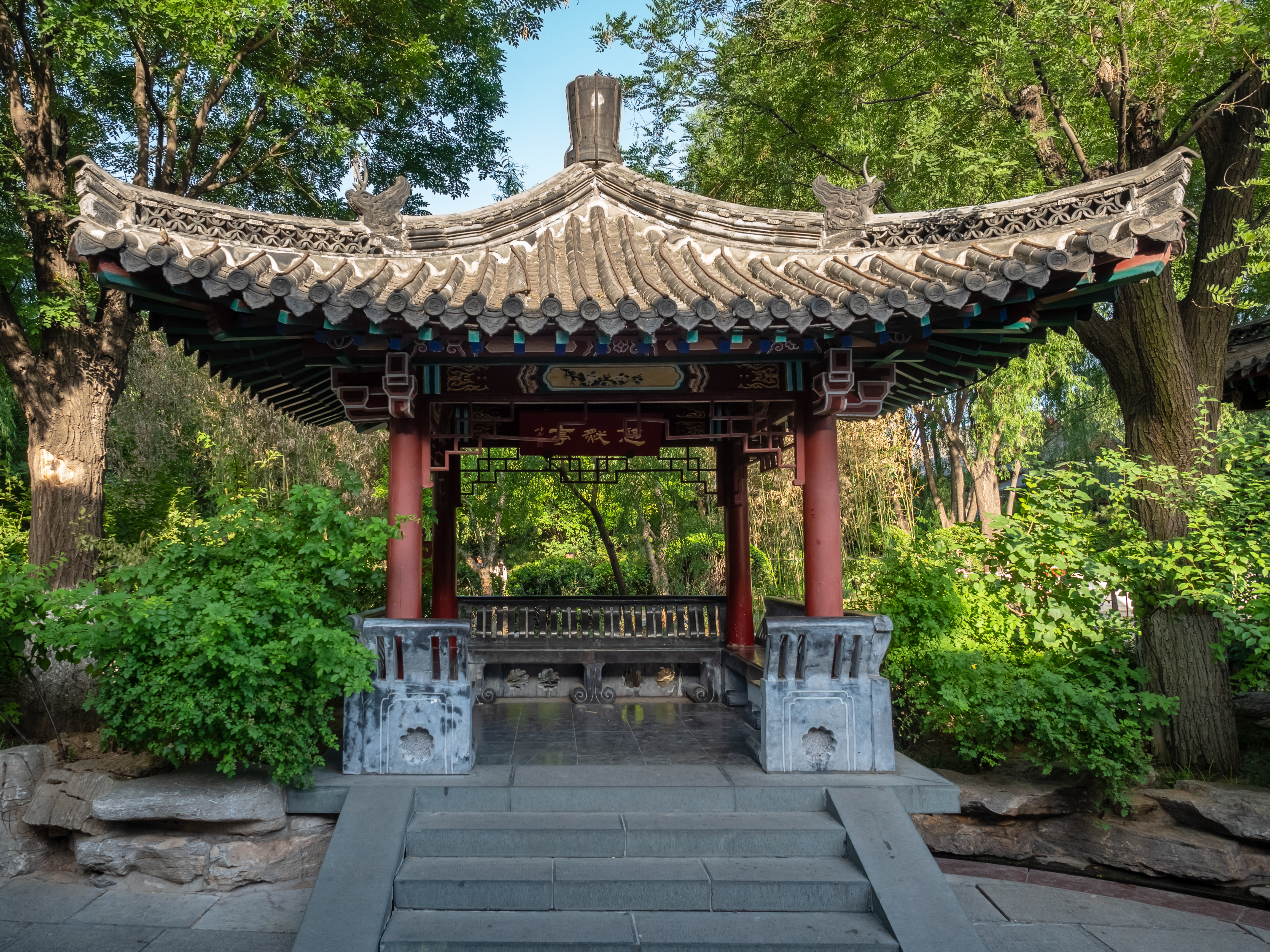 Traditional pavilion surrounded by trees inside Baotu Spring Park in Jinan