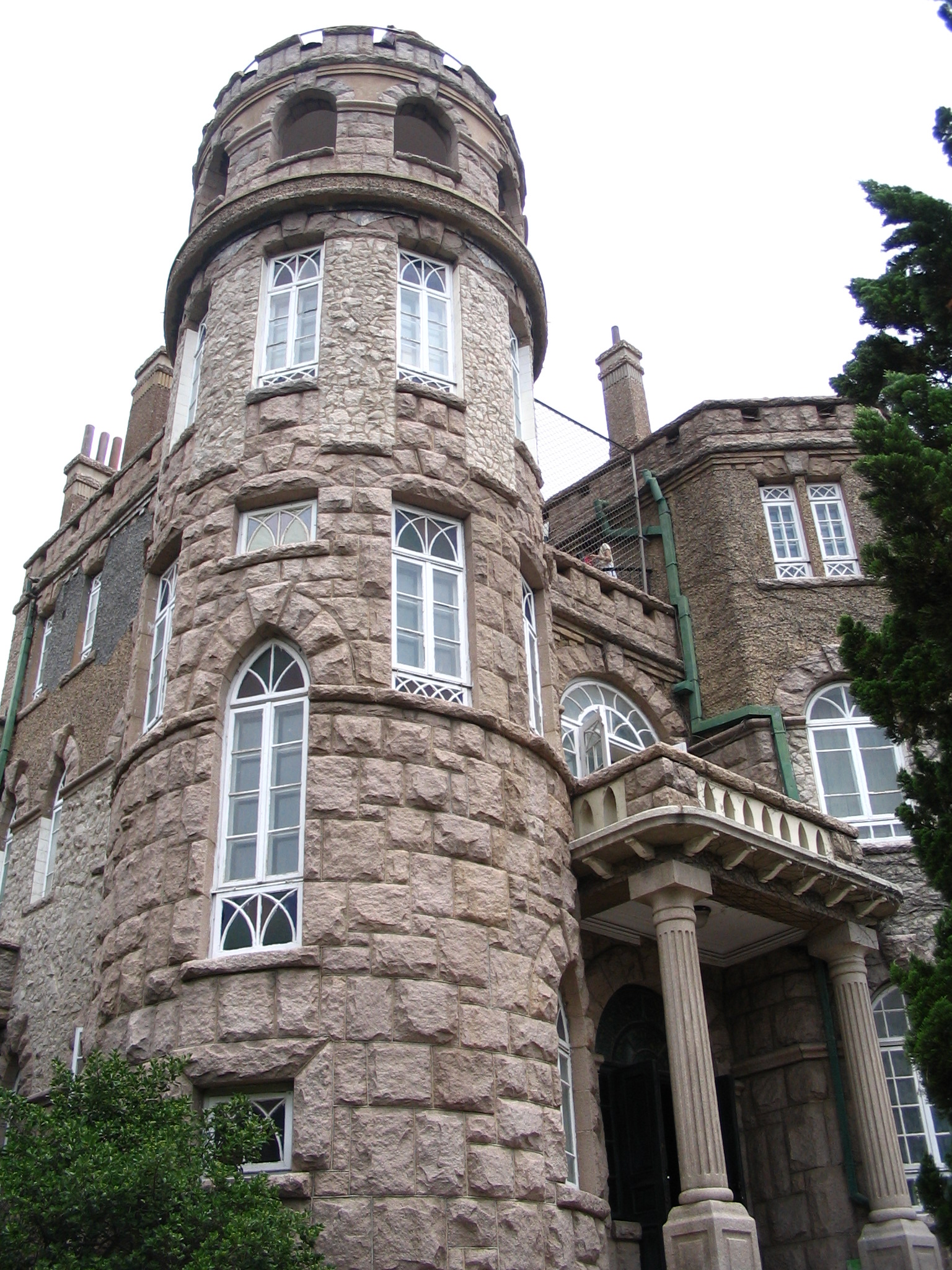 Stone exterior of Huashi Villa among trees in Qingdao's Badaguan district