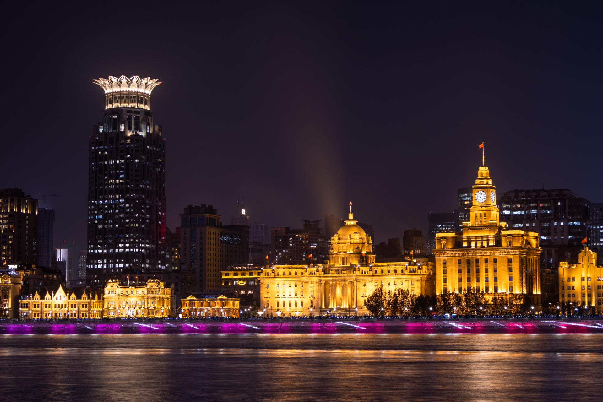 The Bund at night with illuminated historic buildings along the Huangpu River